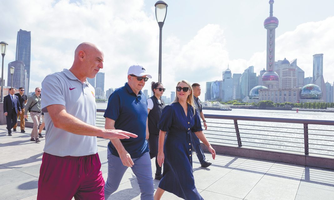 Prime Minister Anthony Albanese and his fiancŽ Jodie Haydon walk along the Bund with former Socceroo and Shanghai Port F